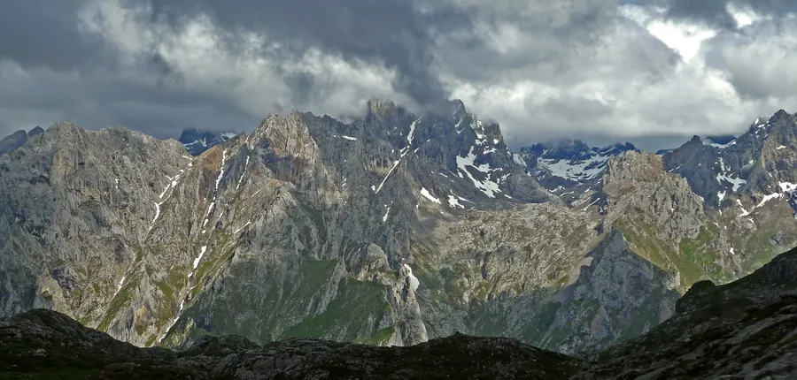 El macizo Central de los Picos de Europa visto desde el collado del Jito, con las agujas calizas de los Urrieles y neveros de junio, en el camino a la Vega de Ario, Parque Nacional de los Picos de Europa, Cangas de Onís (Asturias)