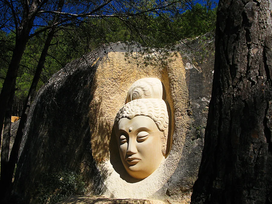 Escultura de Maitreya tallada en la arenisca del pinar de San Isidro, Ruta de las Caras de Buendía